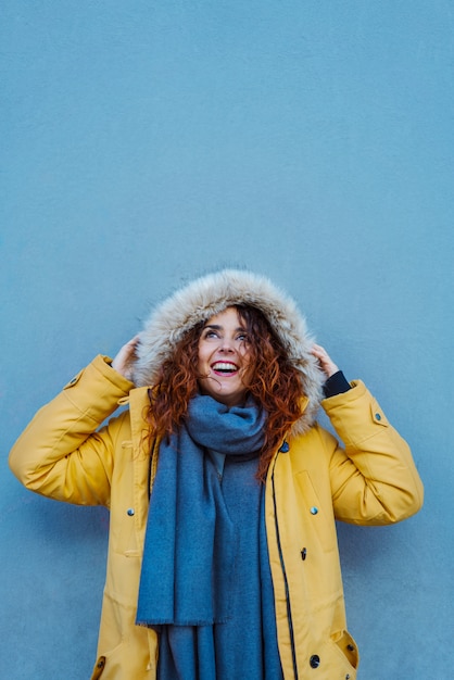 Femme se protégeant avec capuche des pluies d'hiver