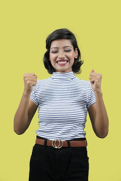 femme se réjouissant, dites oui, semblant heureuse et célébrant la victoire. célèbre le succès avec les bras levés