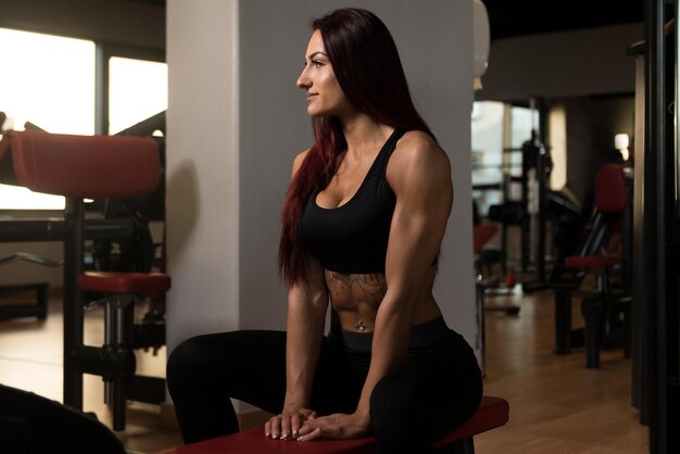 Femme se reposant sur un banc dans un centre de remise en forme