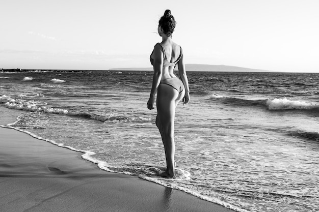 Femme se reposant sur la côte de la mer. Belle jeune femme profitant d'une journée à la plage.