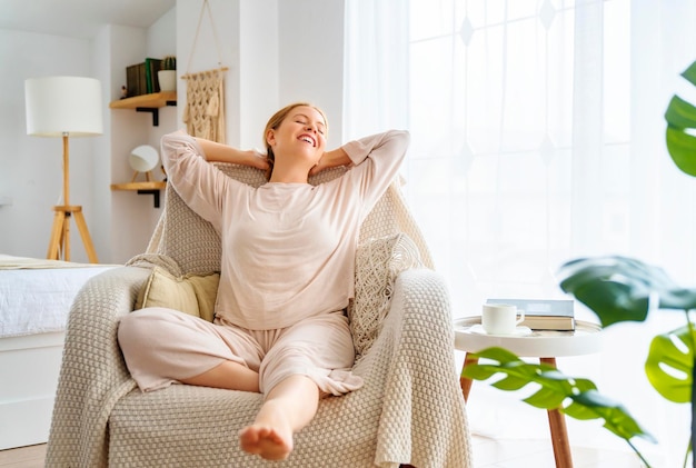 Femme se reposant sur un fauteuil à la maison