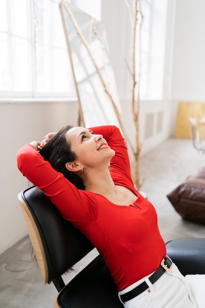 Une femme se repose en souriant de bonne humeur au bureau