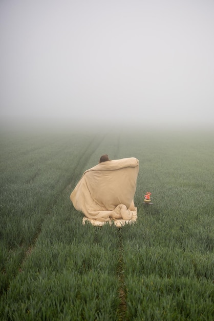 Une femme se réveille dans un champ en plein air.