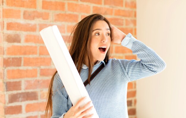 femme se sentant heureuse, excitée et surprise, femme regardant sur le côté avec les deux mains sur le visage