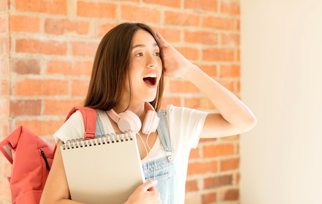 femme se sentant heureuse, excitée et surprise, regardant sur le côté avec les deux mains sur le visage