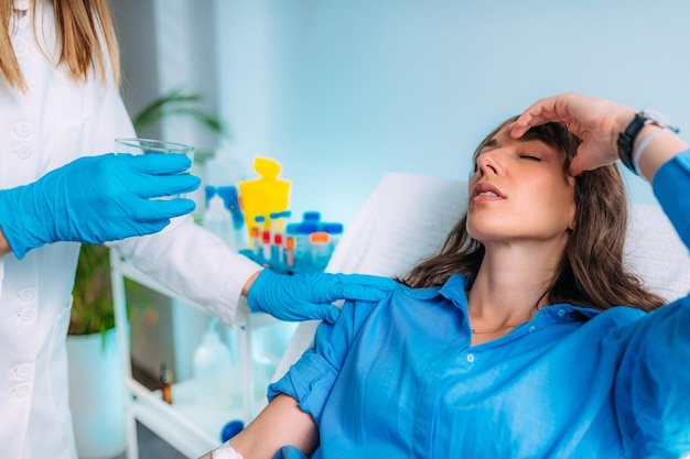 Femme se sentant mal après une prise de sang Infirmière lui donnant un verre d'eau Prise de sang et analyse