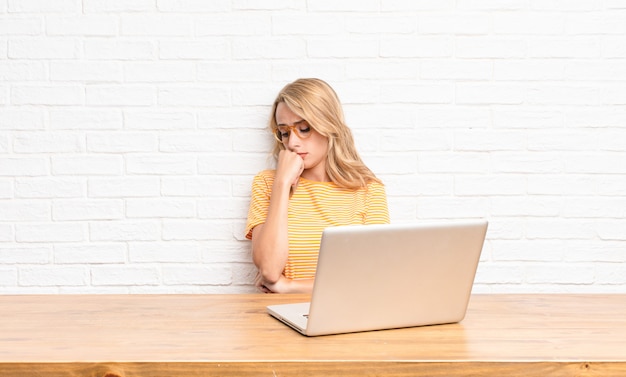 femme se sentant sérieuse, réfléchie et inquiète, regardant de côté avec la main pressée contre le menton