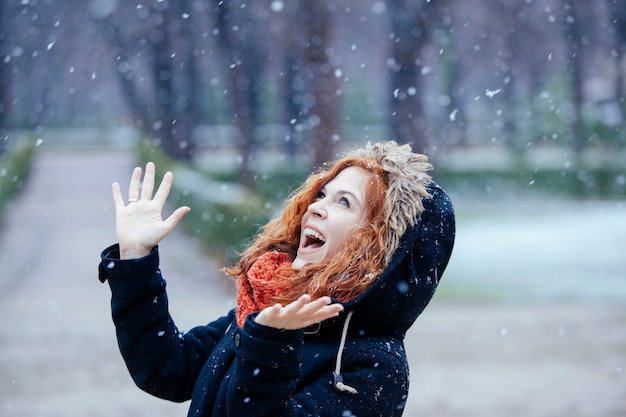 Femme se sentant surprise sous la neige