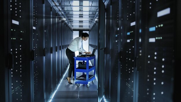 Une femme se tient dans un couloir avec un chariot sur lequel est écrit "cloud computing".