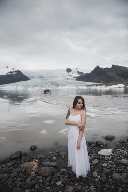 La femme se tient dans la perspective des glaciers en Islande