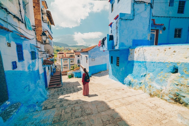 Une femme se tient dans la ville bleue du maroc