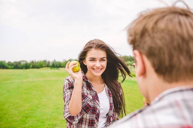 La femme se tient avec une pomme près d'un homme