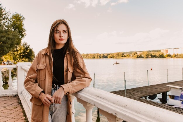 Une femme se tient sur un pont surplombant un lac