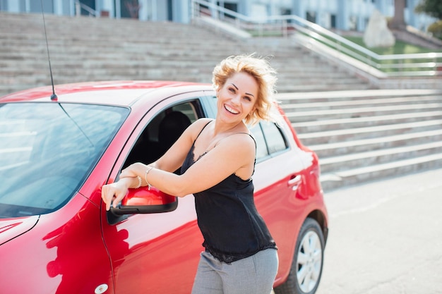 Femme se tient près d'une voiture cassée après un accident appel à l'aide d'assurance automobile