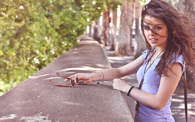 une femme se tient sur un trottoir avec une paire de bracelets