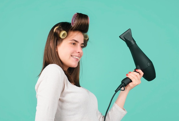 Photo femme avec sèche-cheveux isolé en studio belle fille aux cheveux raides séchant les cheveux avec professi