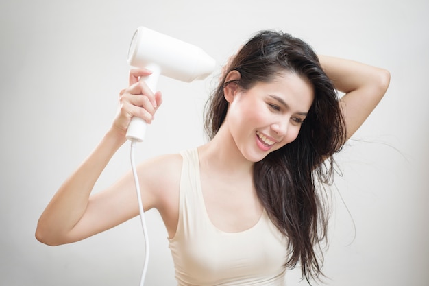 Une femme sèche ses cheveux après la douche