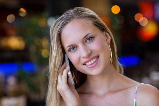 Femme séduisante souriante téléphonant avec smartphone