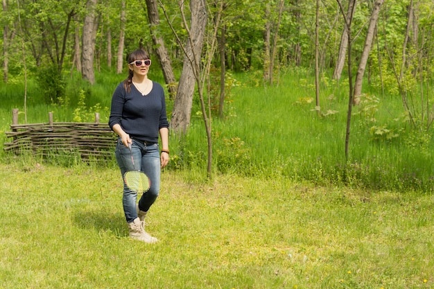 Femme séduisante sportive jouant au badminton en plein air