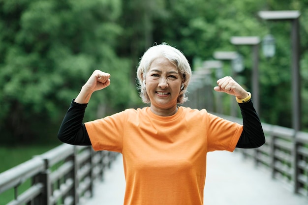 Femme Senior athlétique qui s'étend des bras dans le parc