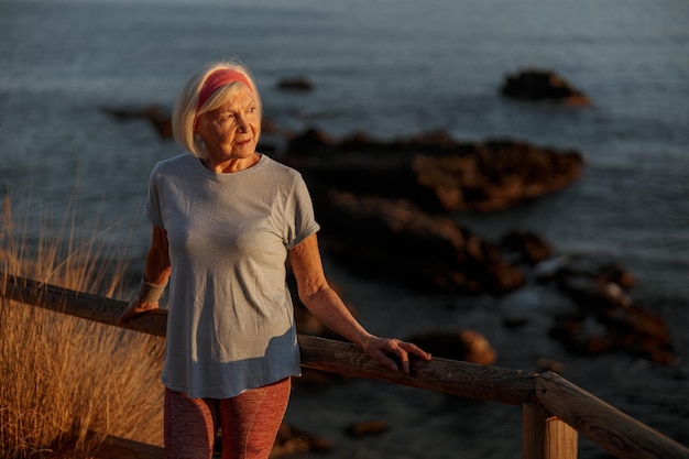 Femme senior caucasienne se reposant après l'entraînement dans la nature