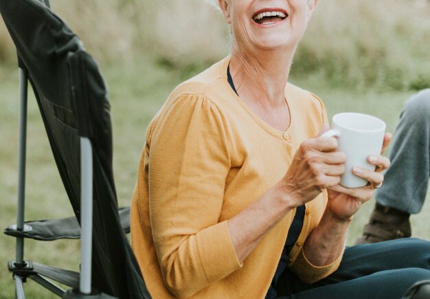 Femme senior joyeuse, appréciant une tasse de café
