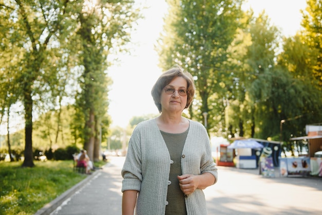 Femme senior souriante ayant des loisirs dans le parc