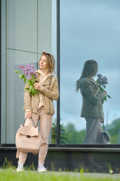 Femme senior sportive avec une branche de lilas à la main