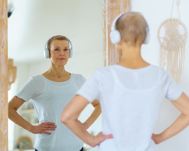 Femme senior sportive s'admirant dans le miroir