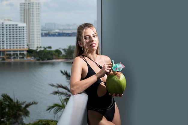 Femme sensuelle en maillot de bain avec des vacances d'été à la noix de coco en ville