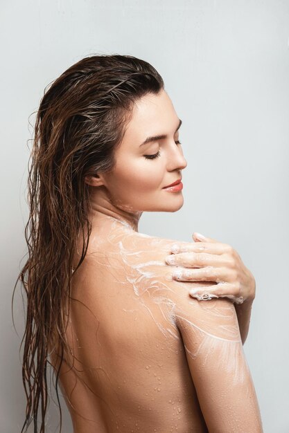 Femme sensuelle se lavant le corps avec du gel douche