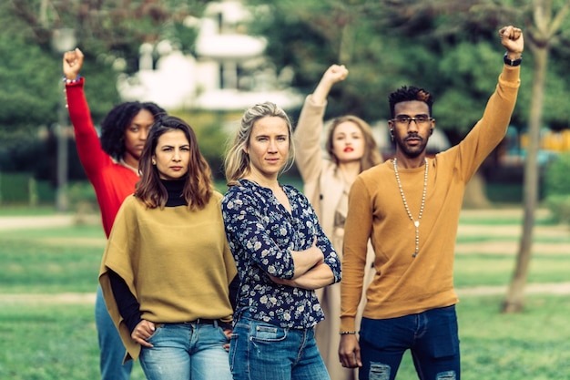 Une femme sérieuse avec les bras croisés dirige un groupe de personnes Une femme sérieuse avec les bras croisés dirige un groupe de personnes