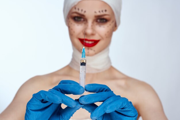 Femme avec une seringue injections de beauté portrait de beauté en studio sur fond blanc