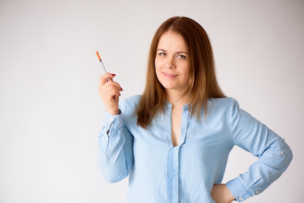 Femme avec une seringue à insuline isolée sur fond blanc - concept du diabète.