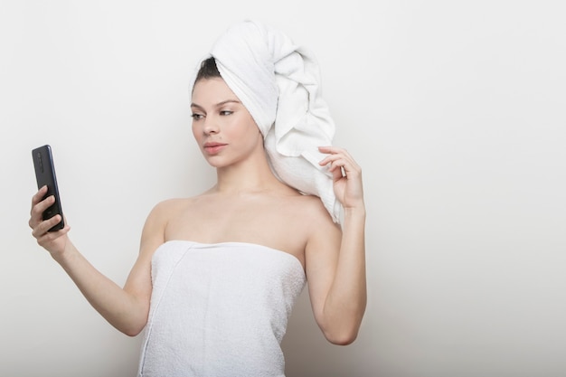 Femme en serviette faisant un selfie