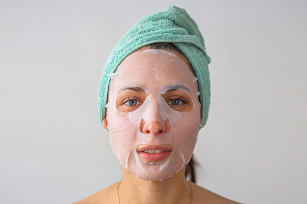 une femme avec une serviette sur la tête et un masque sur son visage