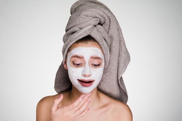 Une femme avec une serviette sur la tête a mis un masque sur son visage