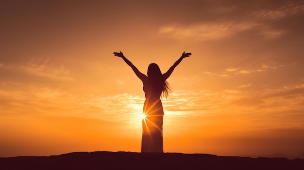 Une femme avec ses bras levés en l'air au coucher du soleil