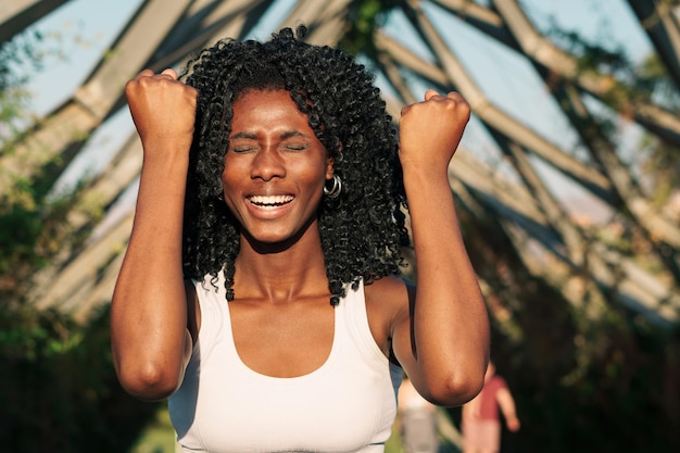 Une femme avec ses mains levées et ses yeux fermés