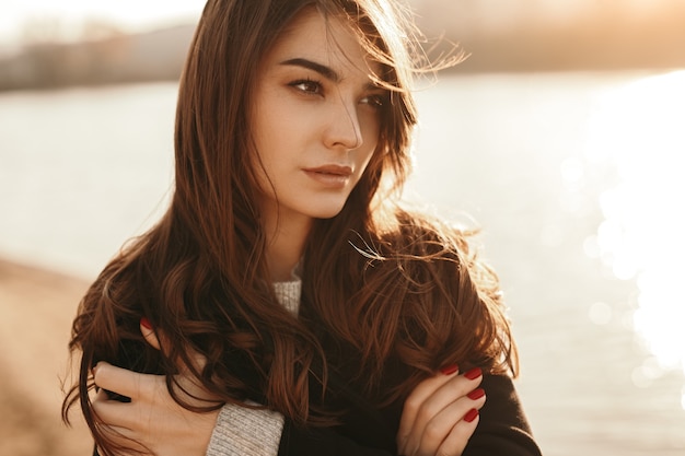 Femme seule debout près du lac par temps froid