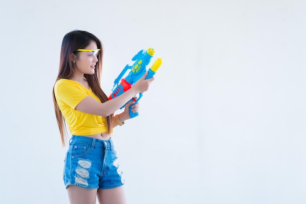 Femme sexy asiatique avec de l'eau à la main sur fond blancFestival songkran day en thaïlandeLe meilleur du festival de la thaïlande du sourire