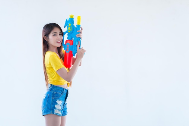 Femme sexy asiatique avec de l'eau à la main sur fond blancFestival songkran day en thaïlandeLe meilleur du festival de la thaïlande du sourire