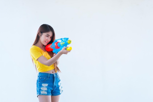 Femme sexy asiatique avec de l'eau à la main sur fond blancFestival songkran day en thaïlandeLe meilleur du festival de la thaïlande du sourire