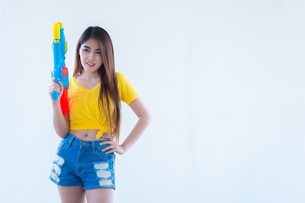 Femme sexy asiatique avec de l'eau à la main sur fond blancFestival songkran day en thaïlandeLe meilleur du festival de la thaïlande du sourire