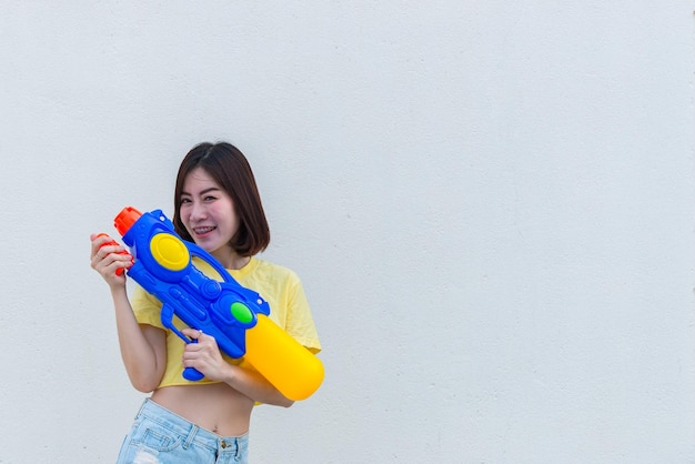 Femme sexy asiatique avec de l'eau à la main sur fond blancFestival songkran day en thaïlandeLe meilleur du festival de la thaïlande du sourire