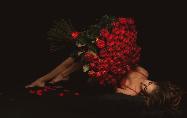 Femme sexy avec bouquet de roses Fille en lingerie rouge avec des roses présentes Saint Valentin