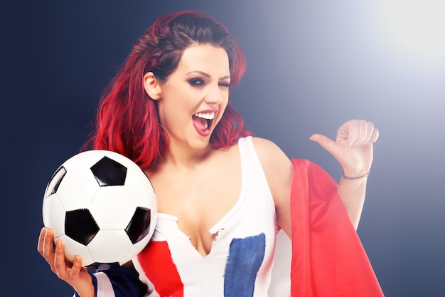 Photo femme sexy portant le drapeau français et tenant le football