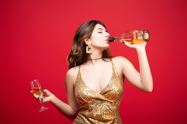 Femme Sexy En Robe D'or Avec Du Champagne Avec Du Rouge à Lèvres Rouge