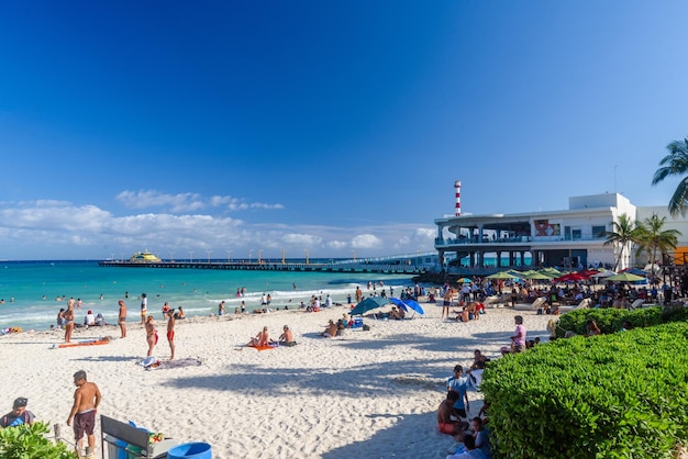 Femme sexy en string tanga bikni et personnes sur la plage de sable avec cocotiers à Playa del Carmen Yukatan Mexique