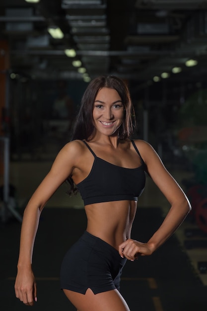 Femme sexy en tenue de sport sur l entrainement en salle de sport. Mode de vie actif athlete feminine seduisante dans un club de remise en forme Photo Premium